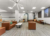 Thumbnail 37 of 61 - A modern office space with brown and green furniture.