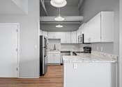 Thumbnail 5 of 58 - A kitchen with white cabinets and a marble countertop.