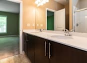Thumbnail 11 of 27 - A bathroom with a green wall and a white counter.