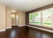 Thumbnail 7 of 27 - A room with brown walls and a wooden floor.