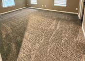 Thumbnail 9 of 27 - A room with a ceiling fan and carpeted floor.