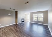 Thumbnail 14 of 27 - A spacious room with wooden flooring and a television set.