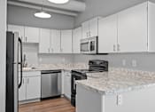 Thumbnail 6 of 58 - A kitchen with white cabinets and a marble countertop.
