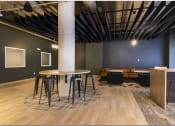 Thumbnail 24 of 28 - a communal area with a round table and stools
