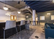 Thumbnail 18 of 28 - a bar with stools and tables in a room with couches and chairs