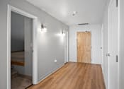 Thumbnail 2 of 58 - A hallway with a wooden floor and white walls.