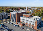 Thumbnail 56 of 61 - A large building with a parking lot in front of it.