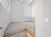 Thumbnail 3 of 58 - A room with a carpeted floor and a wooden bench.