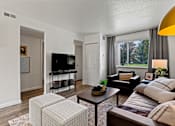 Thumbnail 3 of 19 - A living room with a brown couch, a white chair, and a television. at Vivo Toledo Apartments, Ohio, 43607