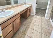 Thumbnail 26 of 27 - A bathroom with a sink, mirror, and a walk-in shower.
