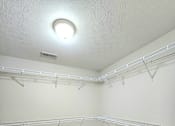 Thumbnail 25 of 27 - A room with a carpeted floor and a ceiling light.