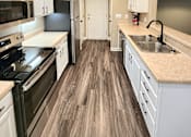 Thumbnail 12 of 27 - A kitchen with black appliances and white cabinets.
