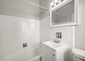 Thumbnail 30 of 48 - a white bathroom with a sink and a bath tub