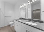 Thumbnail 8 of 61 - A bathroom with a toilet, sink, and mirror.