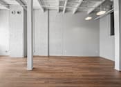Thumbnail 11 of 58 - A large, empty room with wooden floors and white walls.