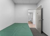 Thumbnail 12 of 61 - A room with a bed and a door.