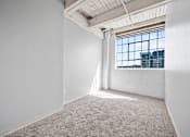 Thumbnail 34 of 58 - A large empty room with a window overlooking a cityscape.