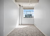 Thumbnail 35 of 58 - A large empty room with a window overlooking a cityscape.