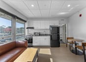 Thumbnail 2 of 61 - A kitchen with white cabinets and a black refrigerator.