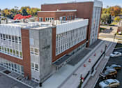 Thumbnail 51 of 61 - A large building with a parking lot in front of it.