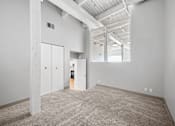 Thumbnail 4 of 58 - A large, empty room with a carpeted floor and white walls.