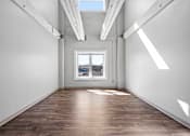 Thumbnail 22 of 58 - A room with wooden floors and a window overlooking a cityscape.