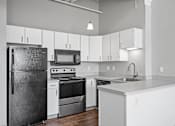 Thumbnail 20 of 58 - A modern kitchen with a black refrigerator, stove, and microwave.