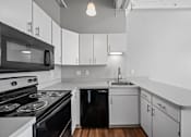 Thumbnail 21 of 58 - A black and white kitchen with a stove, oven, microwave, dishwasher, and sink.