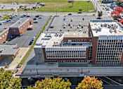 Thumbnail 57 of 61 - A large building with a parking lot in front of it.