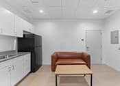 Thumbnail 20 of 61 - A kitchen with a black refrigerator and white cabinets.