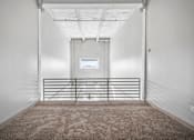 Thumbnail 24 of 58 - A white room with a carpeted floor and a metal gate.