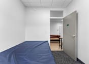 Thumbnail 23 of 61 - A room with a blue tarp on the floor and a door on the right.
