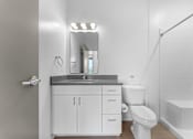 Thumbnail 27 of 61 - A white bathroom with a sink, toilet, and mirror.