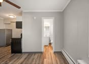 Thumbnail 19 of 48 - a living room with a hard wood floor and a door to a bathroom