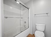 Thumbnail 13 of 58 - A white toilet in a bathroom with a walk-in shower.