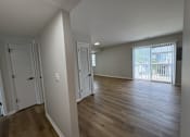 Thumbnail 16 of 18 - A room with wooden floors and white walls.
