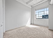 Thumbnail 16 of 58 - A room with a large window and a white door.