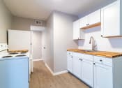 Thumbnail 6 of 19 - Renovated kitchen with white cabinetry
