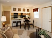 Thumbnail 5 of 13 - A well-lit living room with a dining table and chairs.