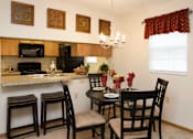 Thumbnail 6 of 13 - A kitchen with a table set for two.