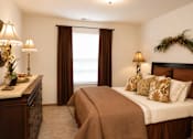 Thumbnail 8 of 13 - A bedroom with a large bed and a window with curtains.
