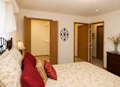 Thumbnail 10 of 13 - A bedroom with a bed, a dresser, and a mirror.