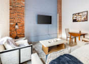Thumbnail 22 of 40 - living room with a brick wall at Life At Agora, Cleveland, OH 44103  