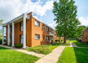 Thumbnail 31 of 35 - a brick apartment building with a sidewalk and trees