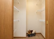 Thumbnail 11 of 13 - A dog is sitting in a basket on a carpet in a room with white walls and a wooden door.