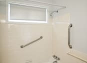 Thumbnail 22 of 31 - a bathroom with grab bars and a shower