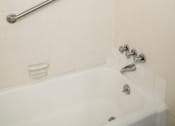 Thumbnail 23 of 31 - a white bath tub in a bathroom with a rail on the wall