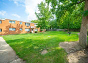 Thumbnail 35 of 35 - the backyard of a brick apartment building with a lawn and trees