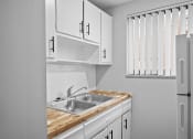 Thumbnail 7 of 35 - the kitchen of our studio apartment has a sink and white cabinets