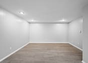 Thumbnail 20 of 35 - an empty room with a wood floor and white walls